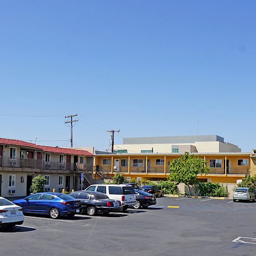 The image shows a "Budget Inn" motel with a parking lot containing several cars and a sign indicating the motel's name.